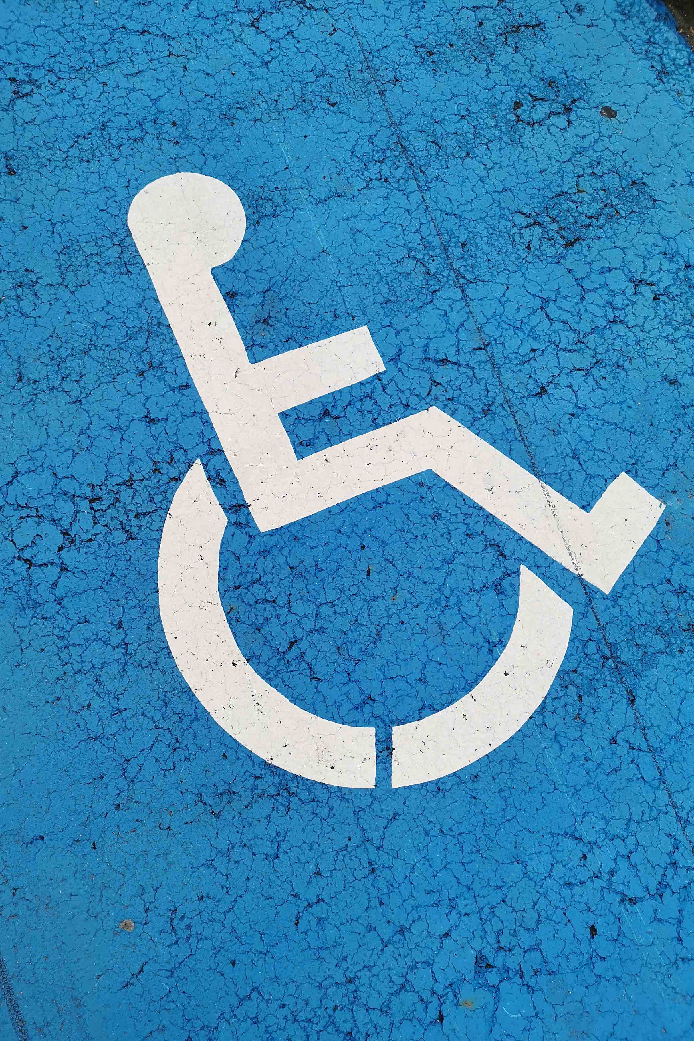 blue handicapped symbol on concrete pavement ground